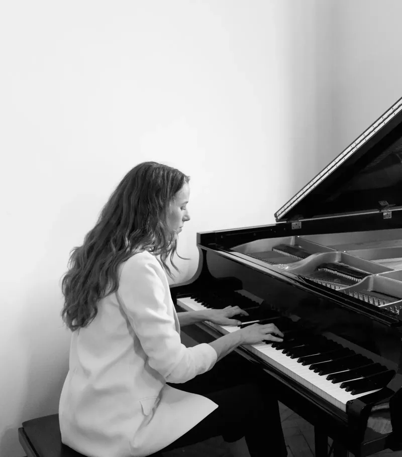 Alexandra Tchernakova in a white blazer at an open grand piano